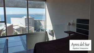 a bedroom with a bed and a view of the ocean at Ayres del Sur in Puerto Madryn +27 photos