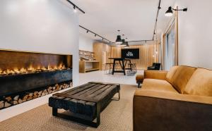 a living room with a couch and a fireplace at das bleibt Alpine Suites in Schladming