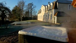 a hot tub in front of a house at Gîte Château de Montboulon 4* Spa+piscine 14pers. in Saint-Georges-sur-Baulche