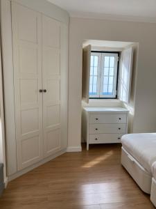 1 dormitorio con 1 cama, vestidor y ventana en Bloom Cottage II, en Sintra