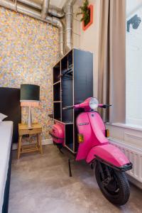 a pink scooter is parked in a room at The Monument Hotel in The Hague