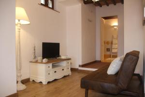 een woonkamer met een bank en een flatscreen-tv bij Maison del Borgo in Colle di Val d'Elsa