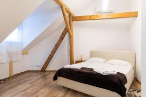 a bedroom with a white bed with wooden beams at Casa Postavarului in Braşov