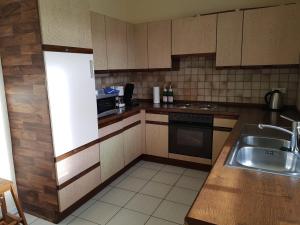 a kitchen with a sink and a stove top oven at Apartment am Vechtesee in Schüttorf