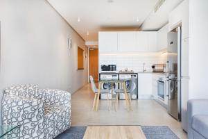 a kitchen and living room with a couch and a table at Always-Power De Waterkant Mountain View Apartment in Cape Town
