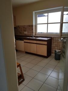 eine Küche mit einem Waschbecken und einem Fenster in der Unterkunft Apartment am Vechtesee in Schüttorf