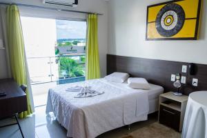 ein Schlafzimmer mit einem Bett und einem großen Fenster in der Unterkunft Hamara Soft Hotel 2 in Altamira