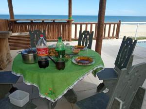 馬里卡的住宿－Casa da Praia Pé na Areia，一张桌子,桌子上摆放着食物和饮料,海滩上摆放着