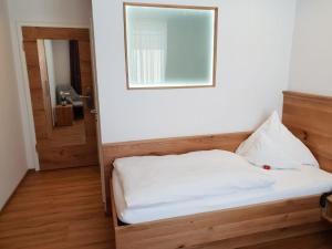 a bed in a room with a mirror on the wall at Kurhotel Roswitha in Bad Wörishofen