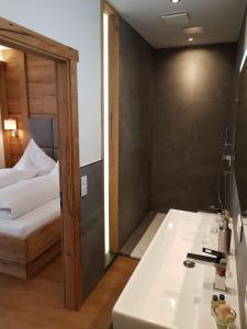 a bathroom with a tub and a bed and a sink at Kurhotel Roswitha in Bad Wörishofen