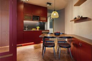 una cocina con armarios rojos y una mesa y sillas de madera. en Downtown Apartments Mitte-Wedding en Berlín