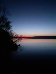 a view of a body of water at night at Stunning log cabin on the lake in Portroe