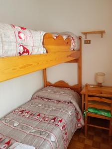 a bedroom with two bunk beds and a table at Vacanze Valmalenco in Chiesa in Valmalenco