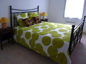 a bedroom with a green and white bed with pillows at Les Capucins in Carcassonne +5 photos