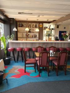 a restaurant with tables and chairs and a bar at Hotel The Ark in 't Zand