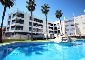 una piscina di fronte a un edificio con palme di AL045 Pinada Beach III La Mata a La Mata