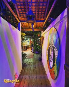 a hallway with a surfboard painted on the wall at Vila Shangri-la Algodoal- Suítes e Redário in Algodoal