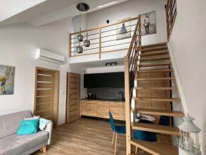 a living room with a staircase leading up to a loft at Apartament Marco in Krynica Morska