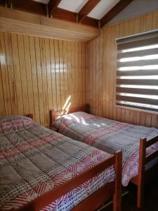 1 dormitorio con 2 camas en una habitación con ventana en Cabañas Mister Nelson, en Valdivia