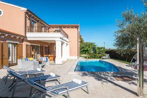a villa with a swimming pool and two lounge chairs at Villa Kanco - managed by Travel Istria in Barban