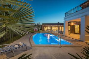 a swimming pool with two chairs next to a house at Villa Kanco - managed by Travel Istria in Barban