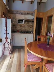 cocina con mesa, sillas y nevera en Cabañas Mister Nelson, en Valdivia