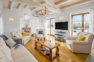a living room with white furniture and a flat screen tv at Villa Kanco - managed by Travel Istria in Barban