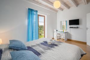 a bedroom with a bed with blue curtains and a desk at Villa Kanco - managed by Travel Istria in Barban +49 photos