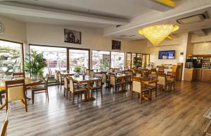 a restaurant with wooden tables and chairs and windows at MidMar Deluxe Hotel in Istanbul