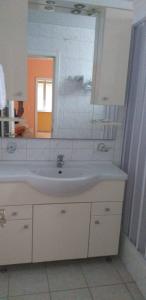 ein Bad mit einem Waschbecken und einem Spiegel in der Unterkunft Lux Apartmani Nikola in Vrnjačka Banja