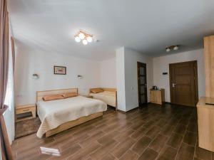 1 Schlafzimmer mit 2 Betten und Holzboden in der Unterkunft Постріл в Комплексі "Сокіл" in Susk