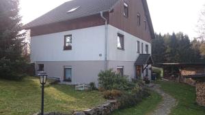 une grande maison blanche avec un éclairage de rue devant elle dans l'établissement Ferienwohnung-Daeumler, à Breitenbrunn/Erzgeb.