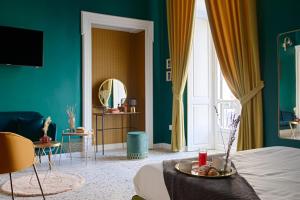 a bedroom with green walls and a bed with a tray of food at Quatrum Napoli - B&B in Naples