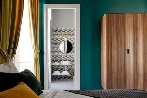 a bedroom with green walls and a door with a mirror at Quatrum Napoli - B&B in Naples