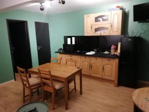 a kitchen with a wooden table and a black refrigerator at Le petit Vaudois in Saint-Parres-lès-Vaudes