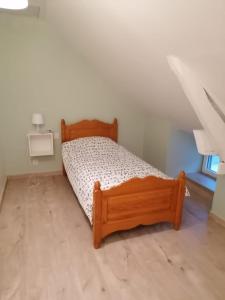 een slaapkamer met een houten bed in een kamer bij Le petit Vaudois in Saint-Parres-lès-Vaudes