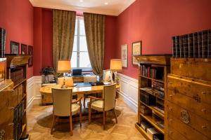 een eetkamer met rode muren en een tafel en stoelen bij La Maison du Sage in Florence