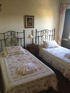 dwa łóżka siedzące obok siebie w sypialni w obiekcie Posta Torreón w mieście Concepción del Uruguay