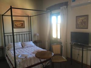 a bedroom with a bed and a table and a window at Posta Torreón in Concepción del Uruguay