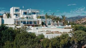 widok na biały dom z palmami w obiekcie The Island Concept Luxury Boutique Hotel Heated Pool w mieście Ajos Nikolaos