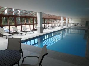 une grande piscine avec des chaises longues et des tables dans l'établissement Vista Azul, à Pedra Azul