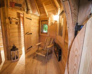 un couloir d'une cabane en bois avec une chaise dans l'établissement Parthénope - Les Cabanes du Chêne Rouvre, à Saint-Dié-des-Vosges