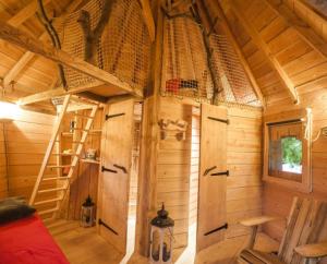 a cabin with a bunk bed and a ladder in it at Parthénope - Les Cabanes du Chêne Rouvre in Saint Die