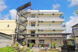 a tall white building with a fire escape at RedDoorz Plus at Pelita Guest House Balikpapan in Balikpapan