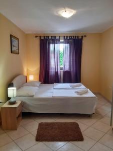 a bedroom with a large bed and a window at Apartments Angela in Žbandaj