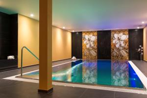 a swimming pool in a hotel with a painting on the wall at Chalet Shalimar in Zermatt