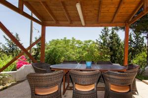 a wooden table and chairs under a wooden pergola at Harmony Country House - Live in the Nature in Kounávoi