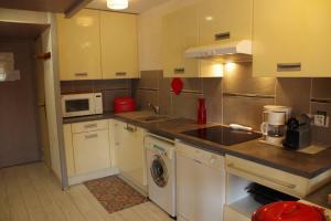 a kitchen with a sink and a washing machine at studio avec climatisation WIFI parking piscine in Cap d'Agde