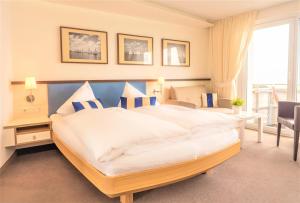 a bedroom with a large white bed with blue pillows at Miramar in Helgoland