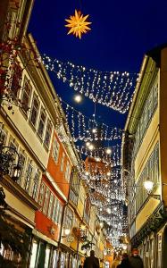 uma rua com luzes de Natal e pessoas a andar por ela em Altstadtapartment an der Krämerbrücke em Erfurt